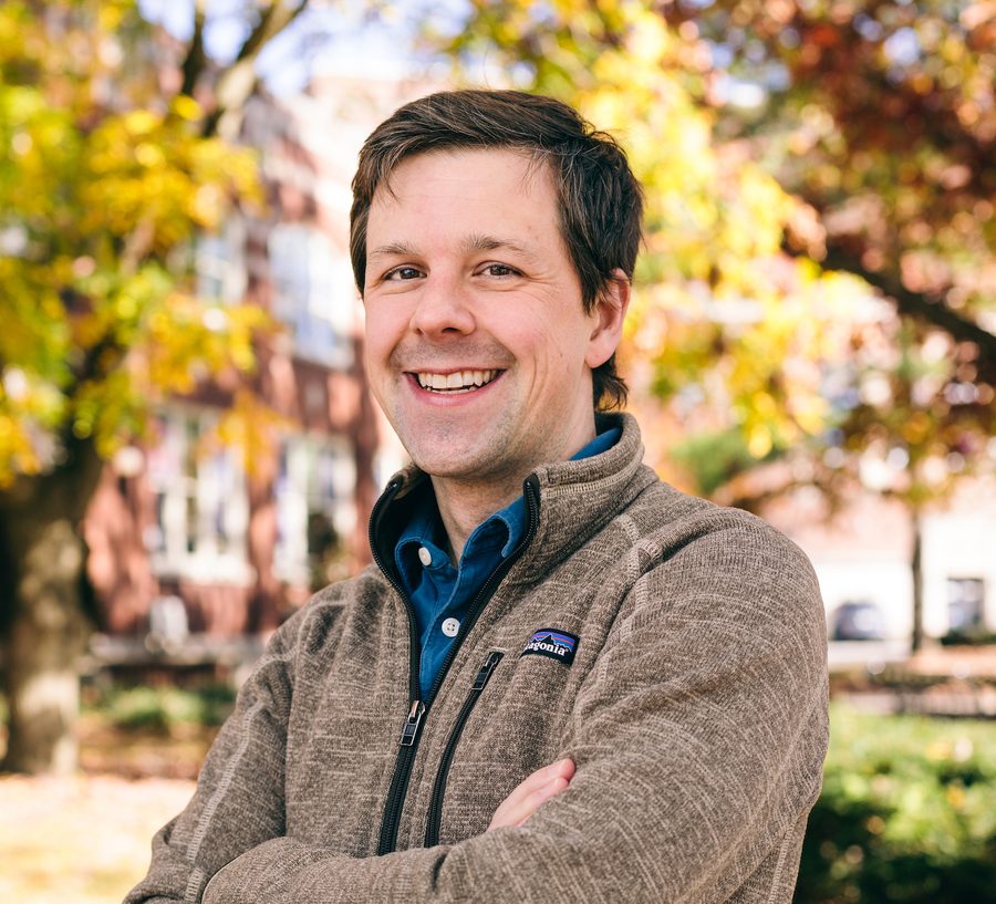 David Gleich with arms crossed in a fleece jacket, cropped close, autumn leaves behind